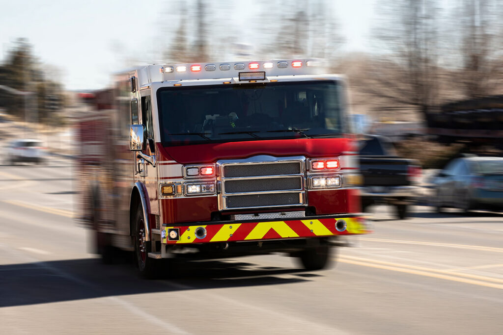 Fire truck racing with sirens blaring to the scene of an emergency.