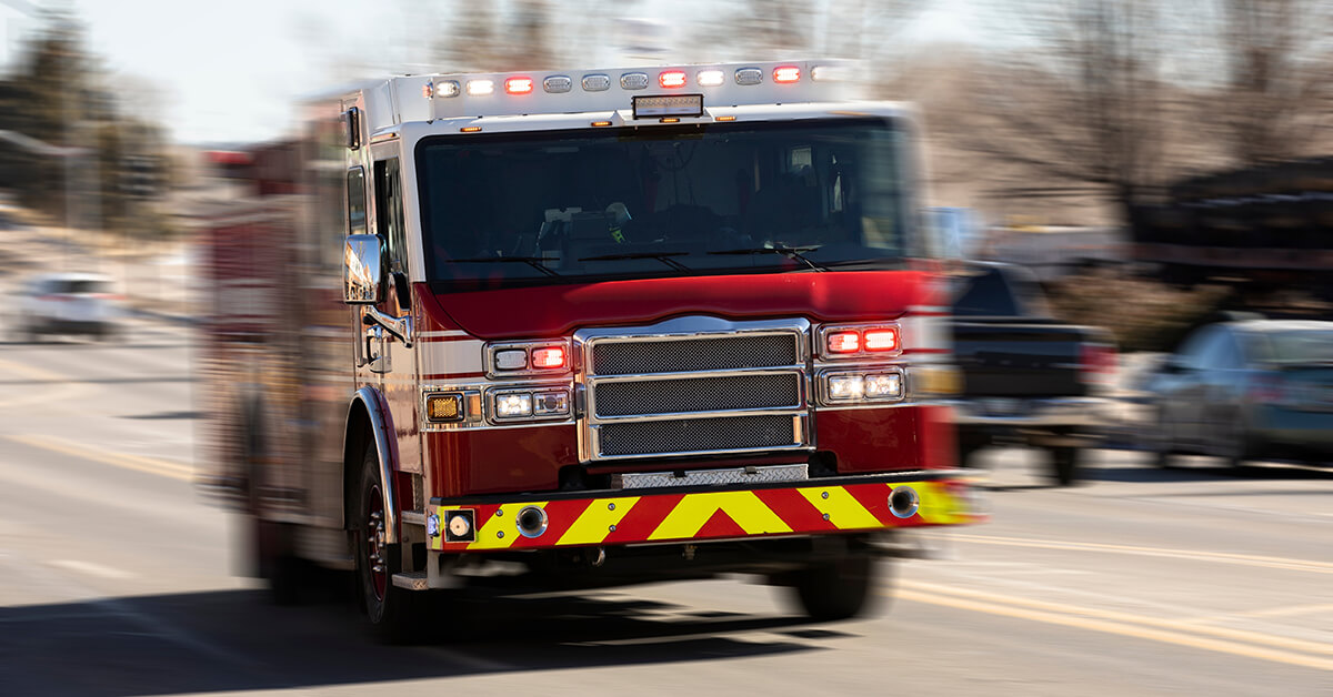 Fire truck racing with sirens blaring to the scene of an emergency.