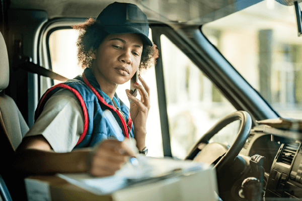 Delivery driver communicating on cell phone inside a work vehicle