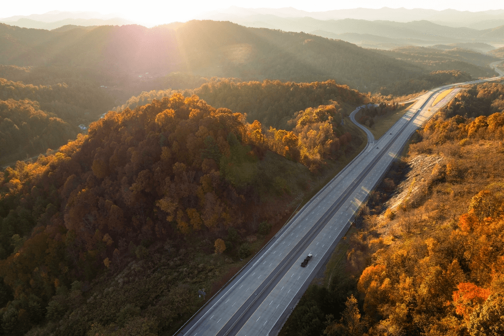 Highway winding through forested mountains during autumn