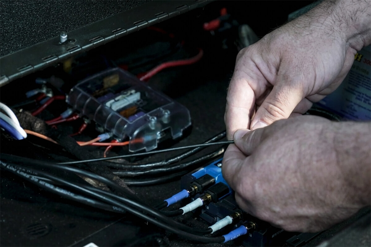 Technician connecting multiple cables and communication equipment inside a vehicle during fleet connectivity installation