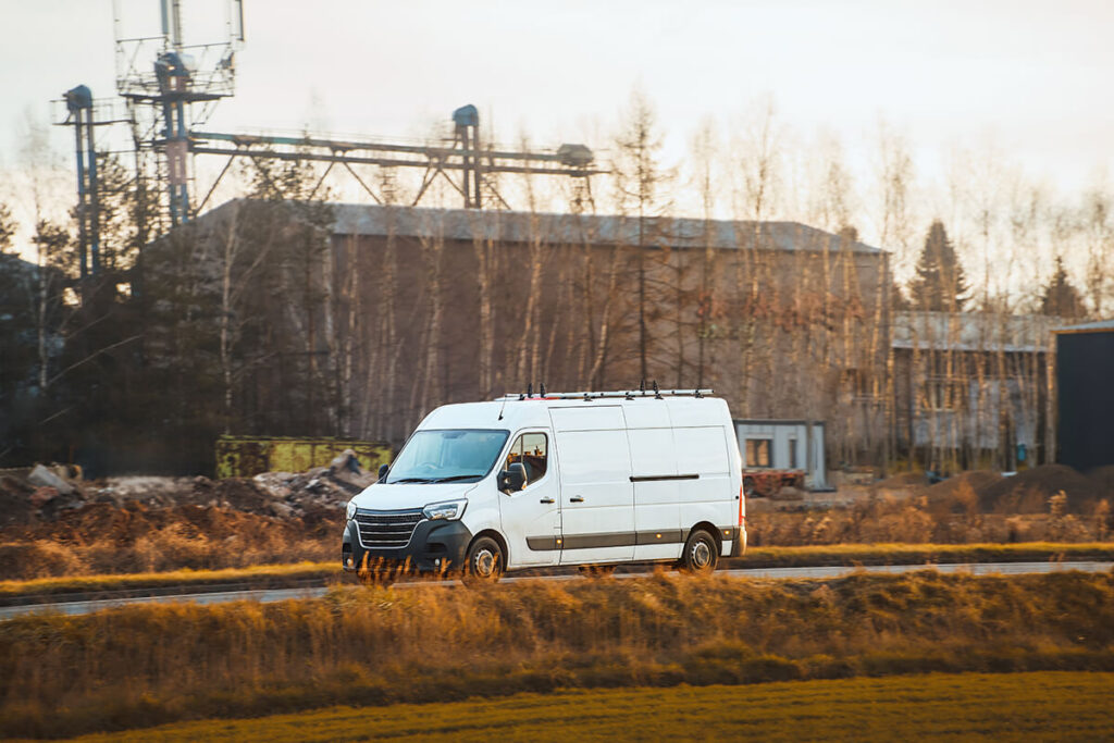 Commercial fleet van driving on a rural road with rooftop antennas installed for mobile connectivity